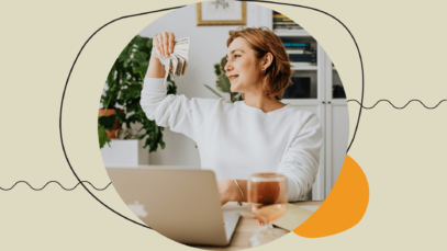 Woman handling money while sitting indoors next to a computer.