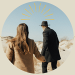 A man and a woman holding hands from the back.