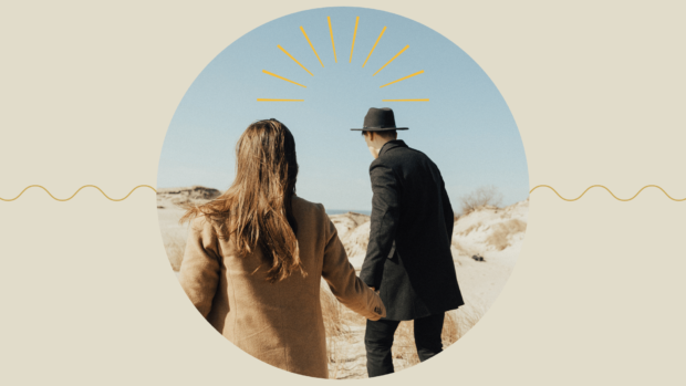 A man and a woman holding hands from the back.